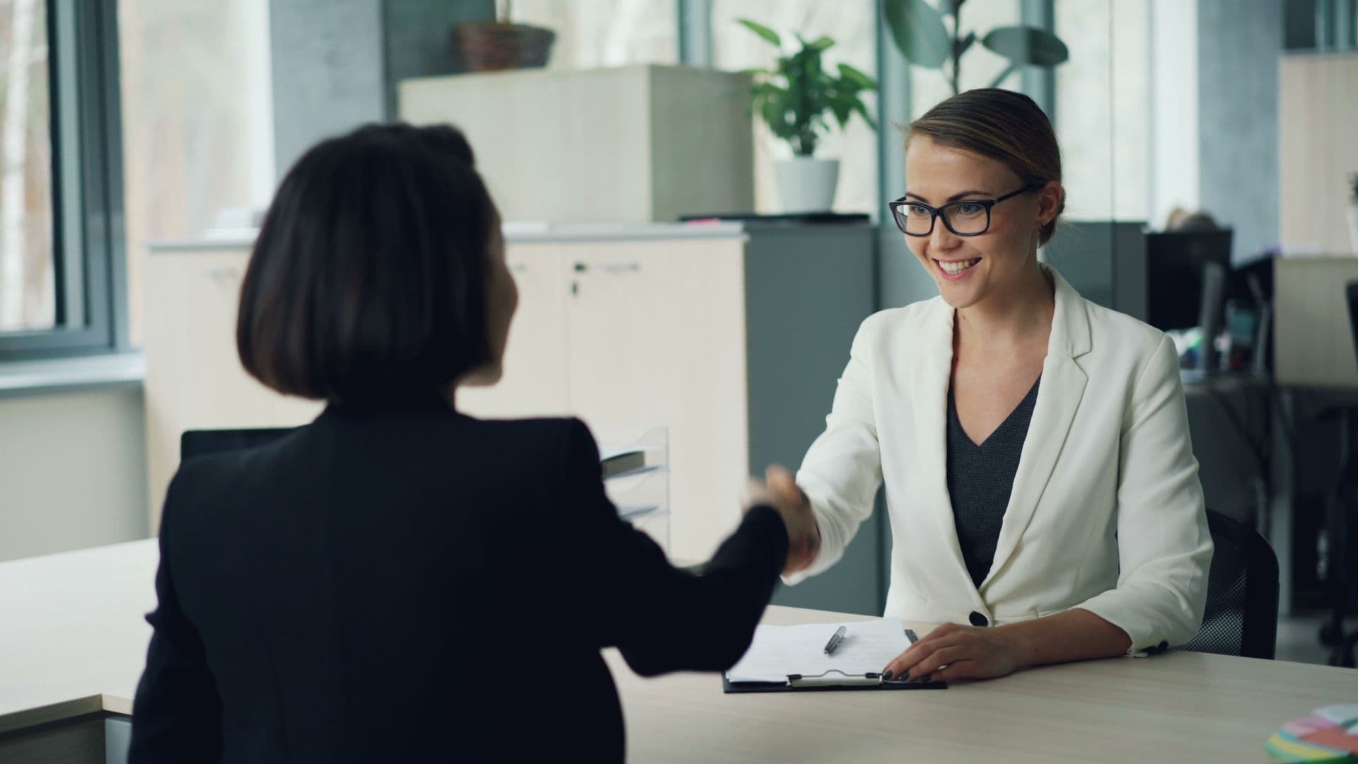 A small business owner shaking hands after reviewing a contract